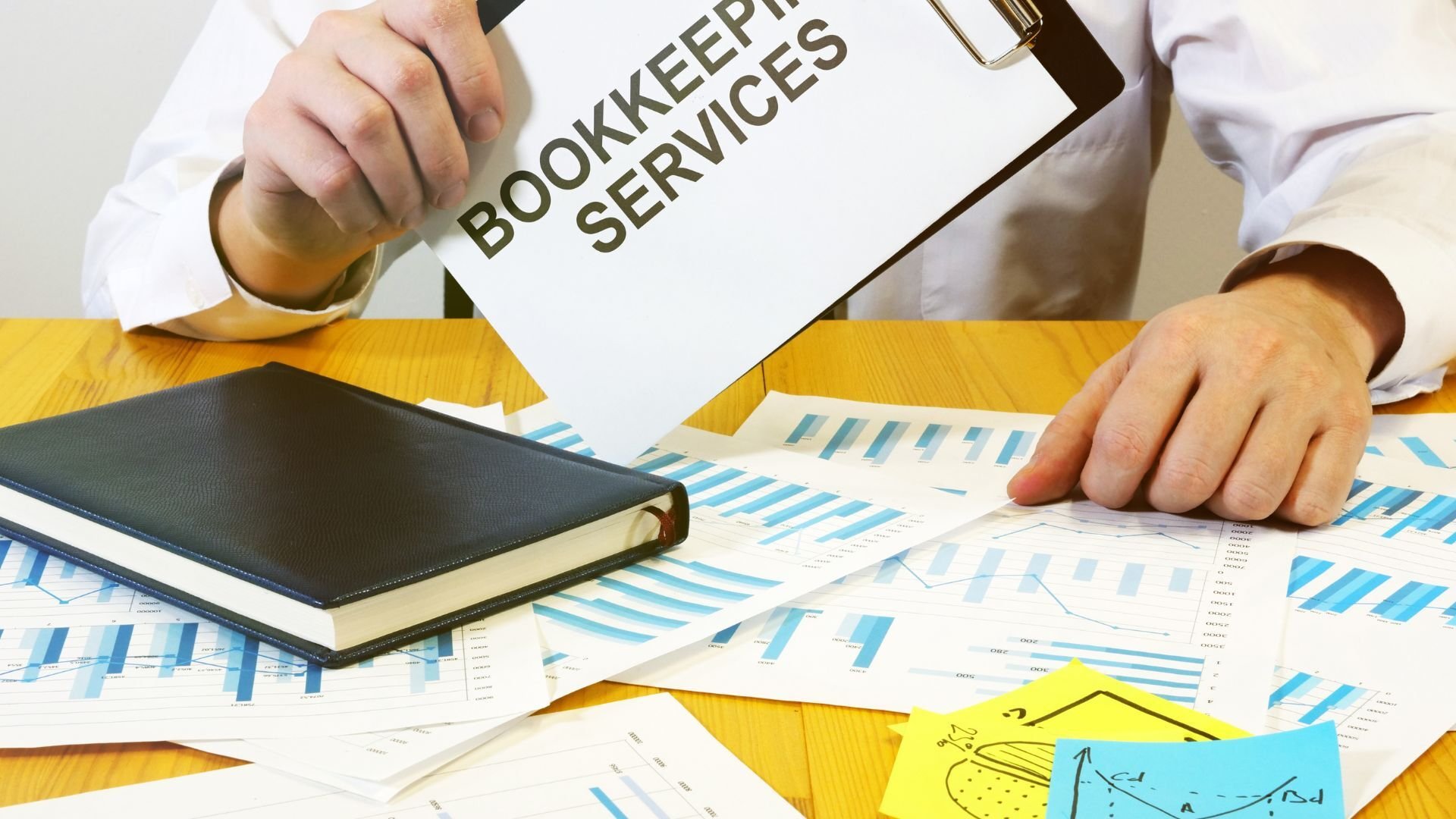 Image Alt Text (under 150 characters):  Business owner reviewing financial reports with a professional bookkeeper, showcasing bookkeeping services benefits.